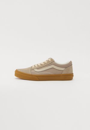 Beige Sneaker aus Wildleder und Canvas mit niedrigem Schnitt, weißem Seitenstreifen, beigen Schnürsenkeln, gepolstertem Kragen und Gummisohle in Karamellfarben.