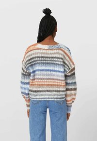 Barevný pletený svetr se horizontálními pruhy v oranžové, šedé, modré a krémové barvě. Volný střih s pokleslými rameny a ribbovanou texturou.
