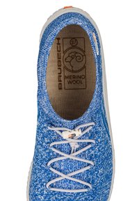 Niebieskie dzianinowe sneakersy o teksturowanej powierzchni, z białymi podeszwami i elastycznymi sznurówkami. Wewnętrzna metka pokazuje "Wełna Merino" oraz logo marki.