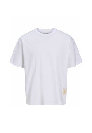 T-shirt blanc à manches courtes et col rond avec un petit patch logo beige près de l'ourlet inférieur sur le côté gauche.