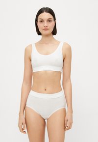 Hvit bomull bralette med brede stropper og bånd. Matchende høy-levd hvite bomulls truser med en myk midje. Enkelt, sømløst design.