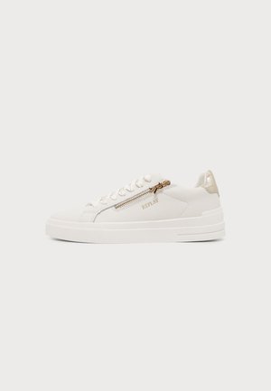 Hvid lavtop sneaker med sidelås, snørebånd foran, gyldne detaljer og "REPLAY" branding på en ensfarvet lys baggrund.