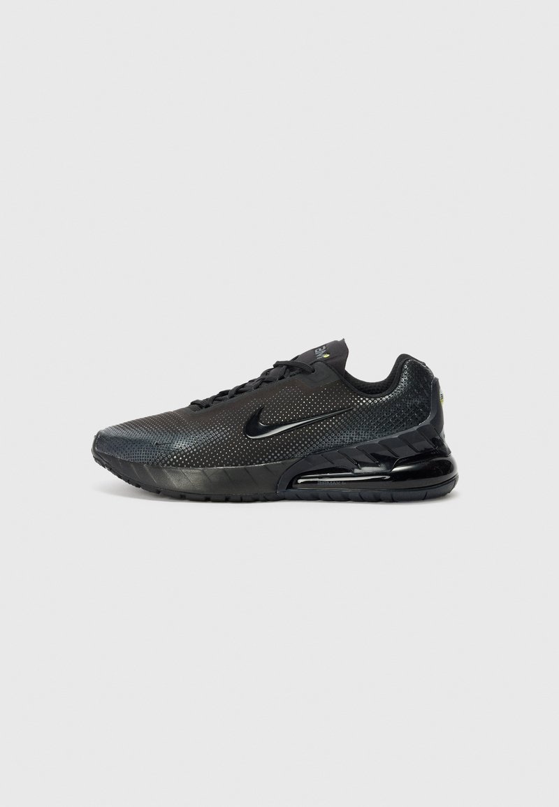 Black athletic shoe with mesh upper, reflective accents, and a cushioned sole. Features a rounded toe and a lace-up design.
