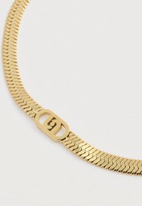 Guldmetal kæd necklace med et fladt, sammenflettet design og en central lukning, der viser et logo. Glat overflade og blank finish.