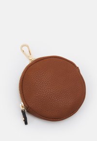 Okrągła brązowa skórzana sakiewka na monety z fakturowaną powierzchnią, złotym zamkiem błyskawicznym i klipsem na górze dla wygody.