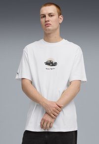 Hvid bomulds t-shirt med et grafisk motiv af en sort bil og ordet "tampa" nedenunder i kursiv. Korte ærmer, afslappet pasform, casual design.