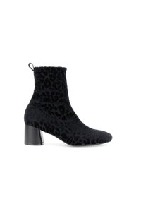Botín de terciopelo negro, con textura de estampado de leopardo, puntera puntiaguda y tacón grueso negro. Cuenta con una lengüeta en la parte posterior.