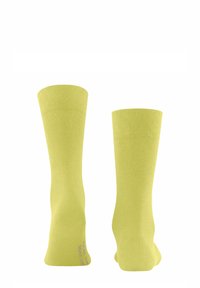 Limettengrüne Baumwollsocken mit einem gerippten Bündchen, glatter Textur und einem Logo an der Unterseite. Sie haben eine Höhe bis zur Mitte der Wade und ein nahtloses Design.