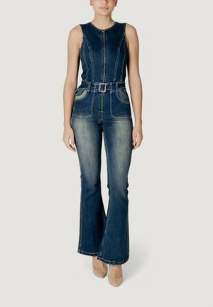 Combinaison en denim au design sans manches, fermeture éclair à l'avant, taille ceinturée, jambe évasée et léger délavage ; couleur bleu profond avec des coutures contrastantes.