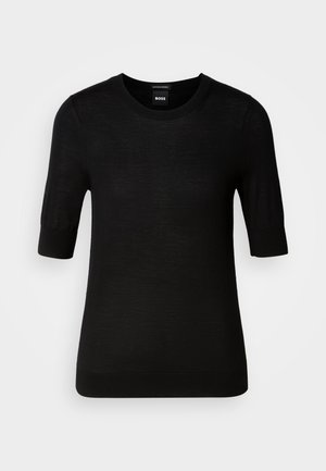 Svart kortermet genser laget av fin merinoull. Rund hals, smal passform, glatt tekstur, minimalistisk design, ingen synlige mønstre eller aksenter.