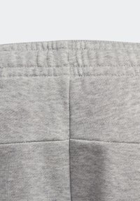 Tela de forro gris con un detalle de costura horizontal, con una textura suave y una cinturilla elástica en la parte superior.