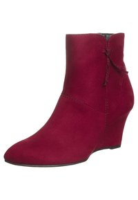 Bottes chevilles en daim rouge avec un talon compensé, un bout pointu et un nœud décoratif à l'arrière. Texture lisse avec des accents cousus.