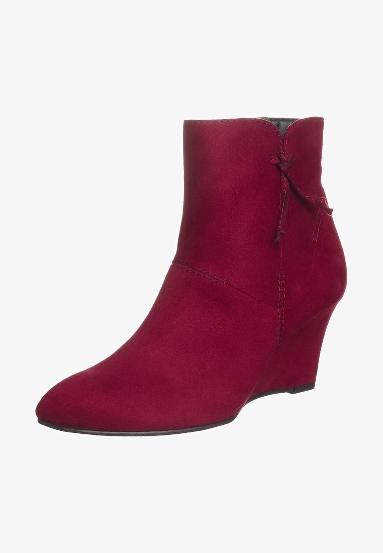 Bottes chevilles en daim rouge avec un talon compensé, un bout pointu et un nœud décoratif à l'arrière. Texture lisse avec des accents cousus.