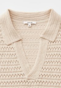 Beige gehäkeltes V-Ausschnitt-Oberteil mit Kragen, verziert mit filigranen Mustern und einem Bekleidungslabel mit der Aufschrift "OPUS" und Größe "36" im Nackenbereich.