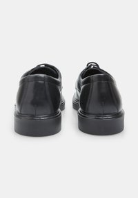 Crne kožne cipele imaju glatku površinu s zaobljenim potplatom, čvrstim crnim đonovima i minimalističkim dizajnom. Nema značajnih uzoraka ili naglasaka.