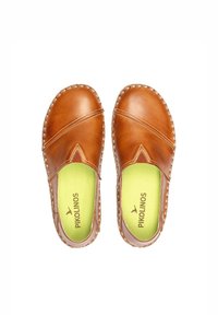 Zapatos informales de cuero marrón con diseño de costura cruzada, costuras en contraste y plantillas verdes con el logotipo de la marca.