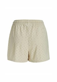Beige Baumwollshorts mit einem elastischen Bund, strukturiertem Stoff und kleinen blütenartigen Mustern. Saumkantennähte, lockere Passform.