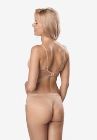 Nude zestaw bielizny składający się z delikatnie teksturowanego biustonosza i dopasowanych fig. Miękka tkanina z regulowanymi ramiączkami i koronkowymi akcentami w talii.