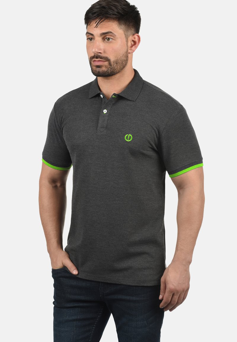 Polo majica u ugljen sivoj boji s zelenim naglascima na ovratniku i rukavima, s dvostrukim dugmetom i malim logotipom na prsima.