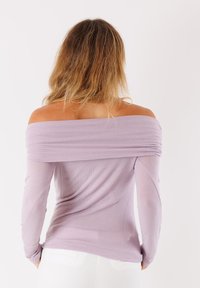Top lilla off-shoulder realizzato in tessuto leggero con maniche lunghe, dotato di dettagli arricciati sulle spalle e una silhouette aderente.