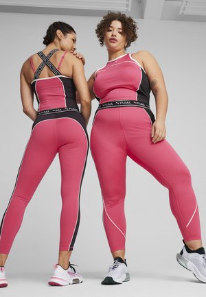 Camisetas deportivas rosas ajustadas y leggins con acentos negros, ribetes blancos y marca PUMA; tela texturizada, diseño de espalda nadadora y ajuste ceñido.