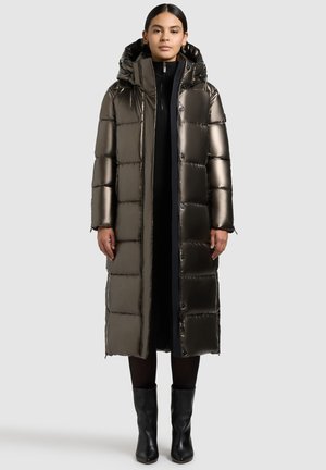 Metallischer, knielanger Puffermantel mit Kapuze; gestepptes Design; glänzende Textur; Frontknöpfe; schwarze Akzente; kombiniert mit schwarzen Stiefeletten.