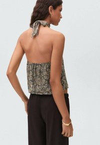 Cropped halter top in a floral pattern with a dark background, featuring a tied neck and elasticized back for a comfortable fit.