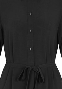 Schwarzes Kleid mit Knopfleiste, langen Ärmeln und gebundenem Taillengürtel. Hergestellt aus leichten Material mit glatter Textur.