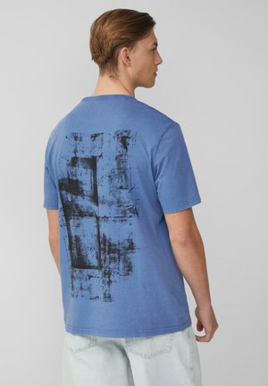 Blaues Baumwoll-T-Shirt mit entspannter Passform, featuring ein großes abstraktes schwarzes Grafikdesign auf der Rückseite. Kurze Ärmel und runder Halsausschnitt.