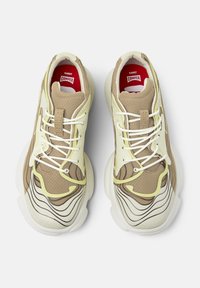 Sneakers w kolorze brązowym i beżowym, z teksturowaną górną częścią z siateczki, kontrastującymi czarnymi i żółtymi akcentami, białą podeszwą środkową oraz czerwoną wkładką z logiem.