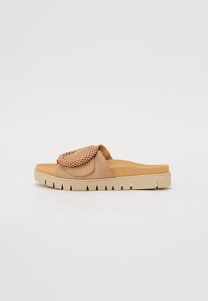 Beige åben tå-slide sandal med tyk sål og dekorativ perlebesat rem over toppen.