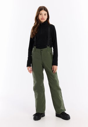 Olijfgroene skibroek met verstelbare bretels, ritszakken en een rechte pasvorm, gecombineerd met een zwarte ribbelige zip-up top.