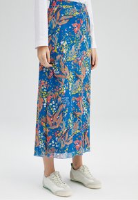 Maxi kjol i ett livfullt blått tyg med färgglada blommor och bladmönster, semitransparent struktur och rak silhuett.