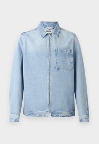 Lys blå denimjakke med glidelås, krage, lange ermer, og brystlomme. Har en lett falmet tekstur og standard mansjetter.