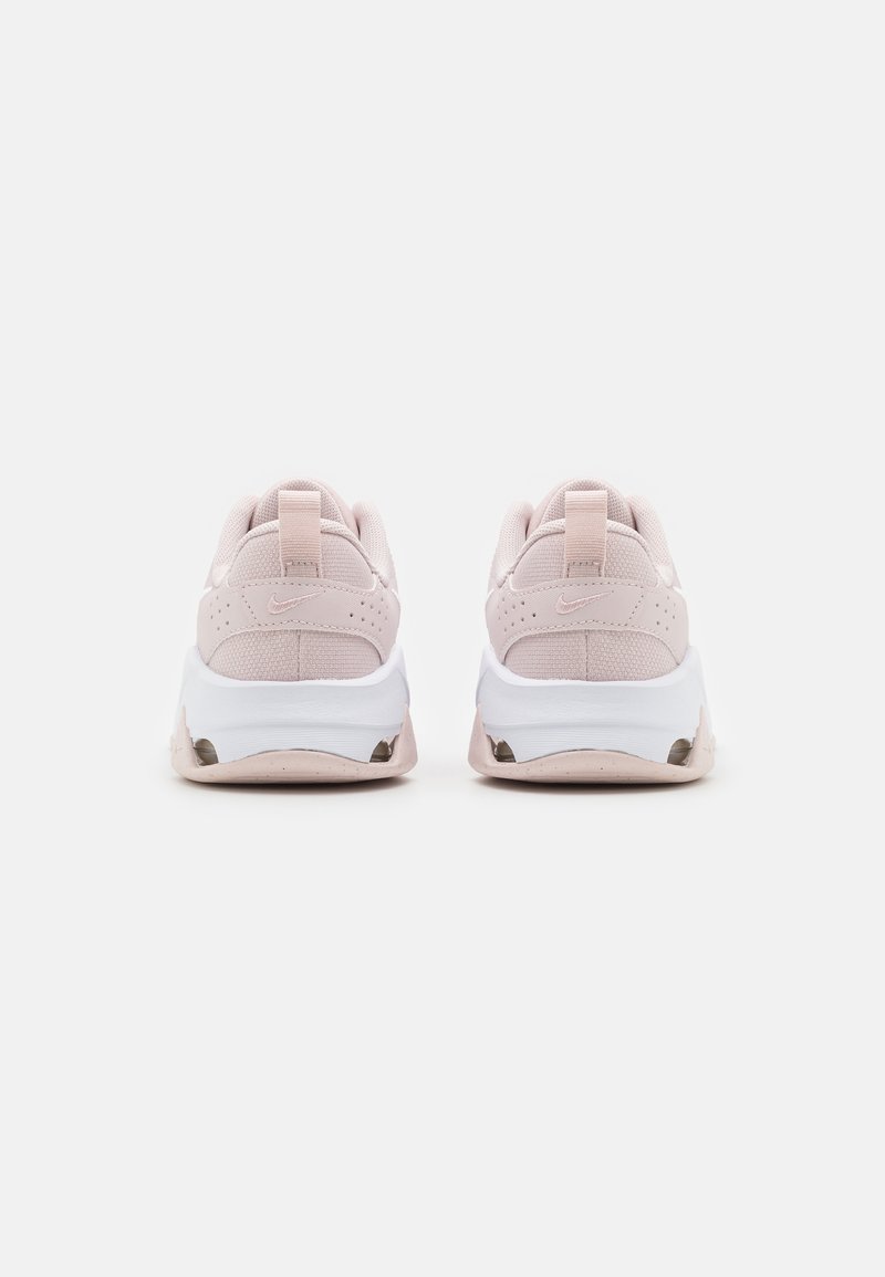 Baskets roses pâles avec une tige en maille texturée, semelle intermédiaire blanche et détails en caoutchouc, dotées d'une languette à l'arrière et d'un marquage subtil sur le talon.