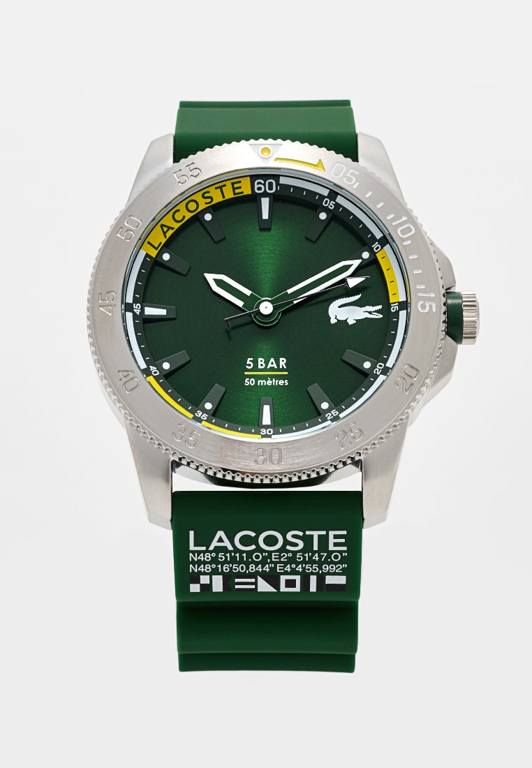 Reloj Lacoste verde con caja de acero inoxidable, esfera verde texturada, acentos plateados, correa de goma y un atrevido marcador de minutos amarillo.