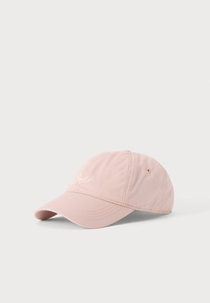 Casquette de baseball rose clair avec une visière courbée et un petit texte blanc brodé à l'avant, présentée sur un fond blanc uni.