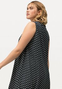 Námořnické modré bezramínkové šaty s bílým květinovým vzorem, jemně rozšířený střih a hladká textura. Šev na zadní straně, lehká tkanina.