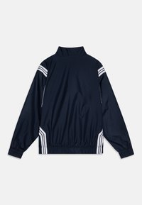 Navy windbreaker jacket with a high collar, elastic waistband, and white striped accents on shoulders. Smooth, lightweight material.