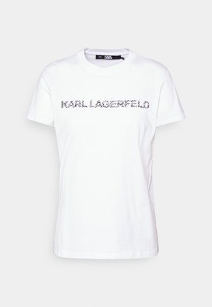 Hvid T-shirt med korte ærmer og teksten "KARL LAGERFELD" i sort zebra-stribet mønster hen over brystet.