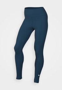 Marineblauwe legging met een hoge tailleband, gemaakt van soepele stof. Heeft een geborstelde textuur en een wit Nike-logo op het onderbeen.