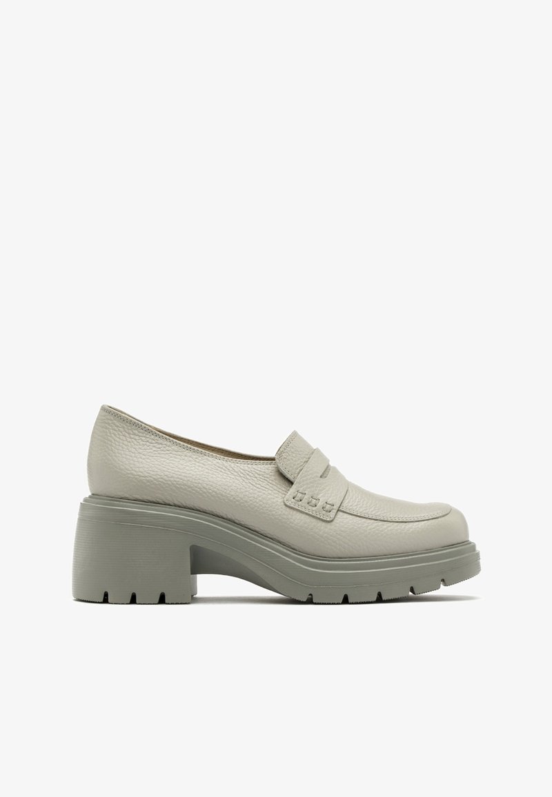 Mocassin gris clair à talon épais, empeigne en cuir texturé et semelle épaisse à relief, vue de côté sur fond blanc.