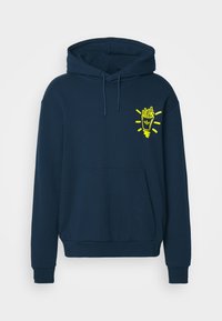 Tumesinine kapuutsiga dressipluus ees tasku, nööriga kapuuts ja kollase friikartulipaki graafik kergelt kiirgavate joontega vasakul rinnal.