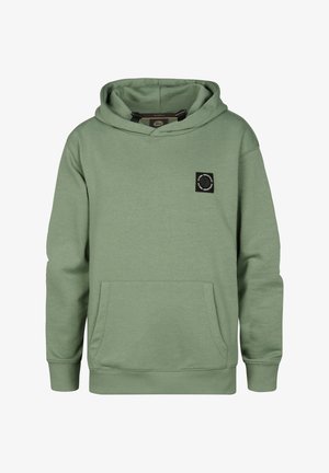 Zielona bluza z kapturem z przednią kieszenią, długimi rękawami i czarną okrągłą naszywką z logo. Nosi się ją z szarymi jeansami i białymi tenisówkami.