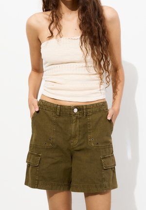 Bermudas cargo en verde oliva con un ajuste relajado, que cuentan con dos bolsillos frontales y dos bolsillos laterales, fabricadas en un tejido suave y texturizado.