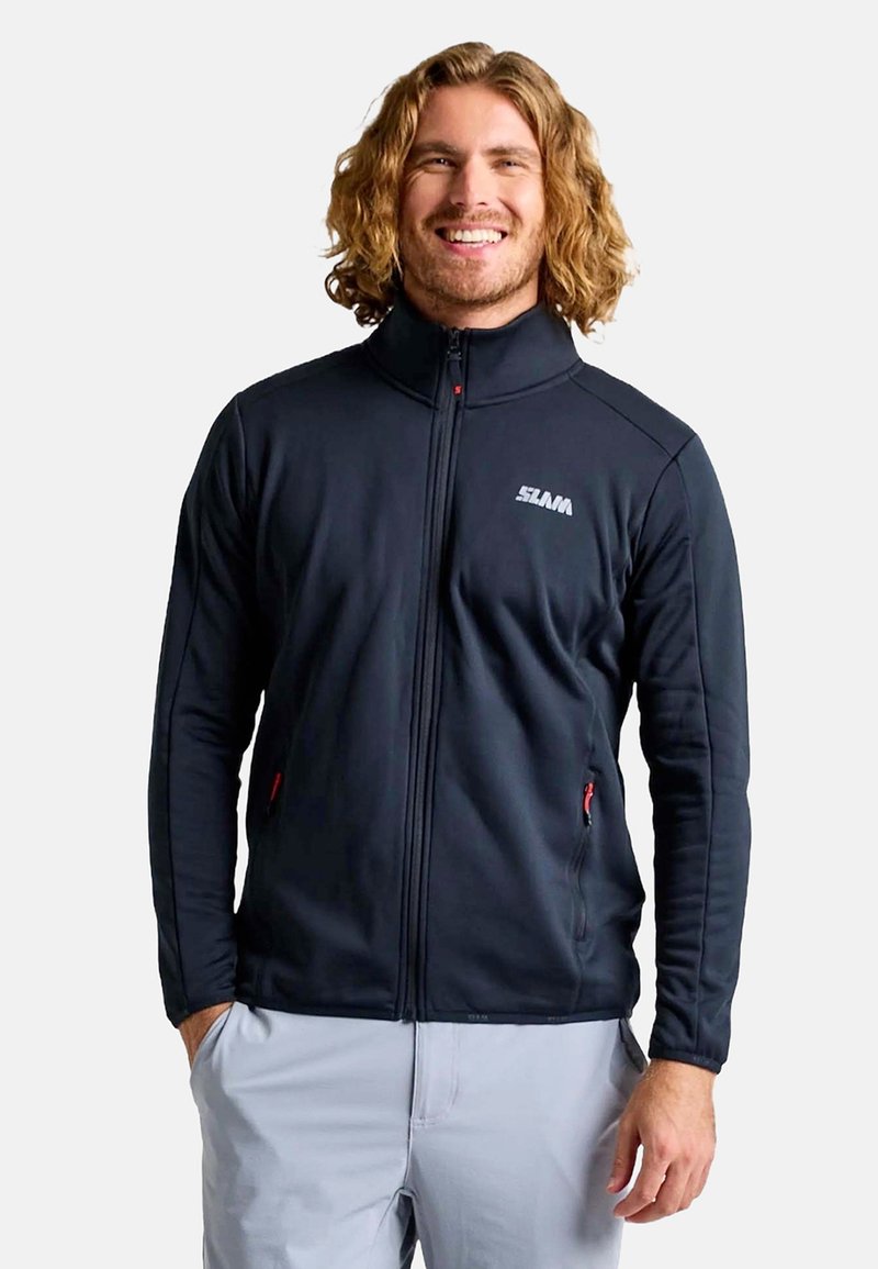 Veste polaire zippée noire avec un col montant, comprenant des accents de fermeture éclair rouges et un logo sur la poitrine gauche. Texture lisse et design ajusté.