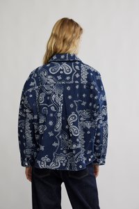 Tumesinine teksasärk valgete paiseliste ja lillemustritega. Omab nööbitavaid mansette ja klassikalist kraed. Vabaaja lahtine disain.