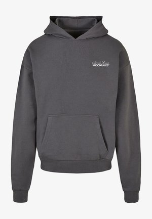 Pelēks kapucēts džemperis, kas izgatavots no ribota auduma, ar priekšējo kabatu un baltu apdrukātu logotipu augšējā kreisajā stūrī.