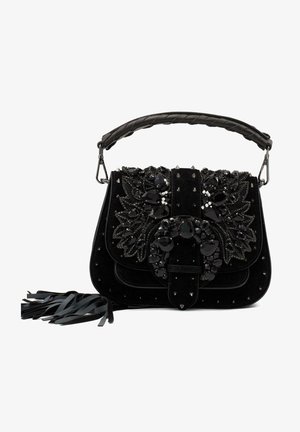 Bolso de terciopelo negro con adornos de joyas, tachuelas metálicas, asa trenzada y acentos con flecos. Forma rectangular compacta.