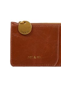 Brown leather wallet with a textured finish, zip closure, and a gold circular tag engraved with "nat & min." Features card slots on one side.